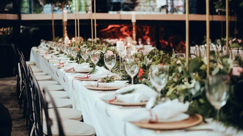 Long dinner table dressed with white florals and candles