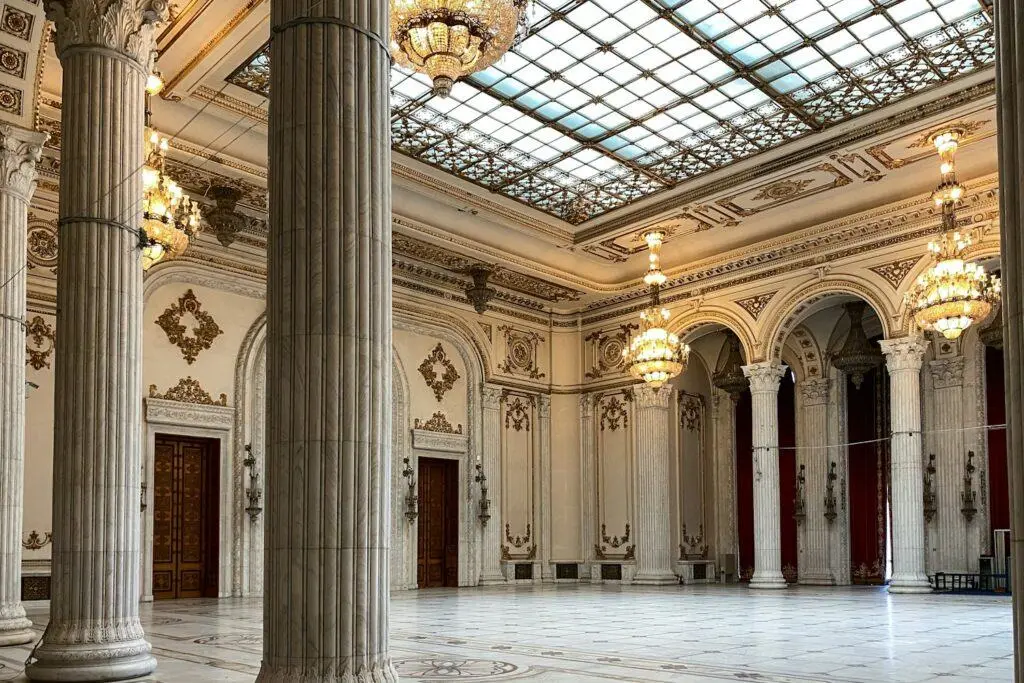 Grand hall with marble columns beneath a glass ceiling